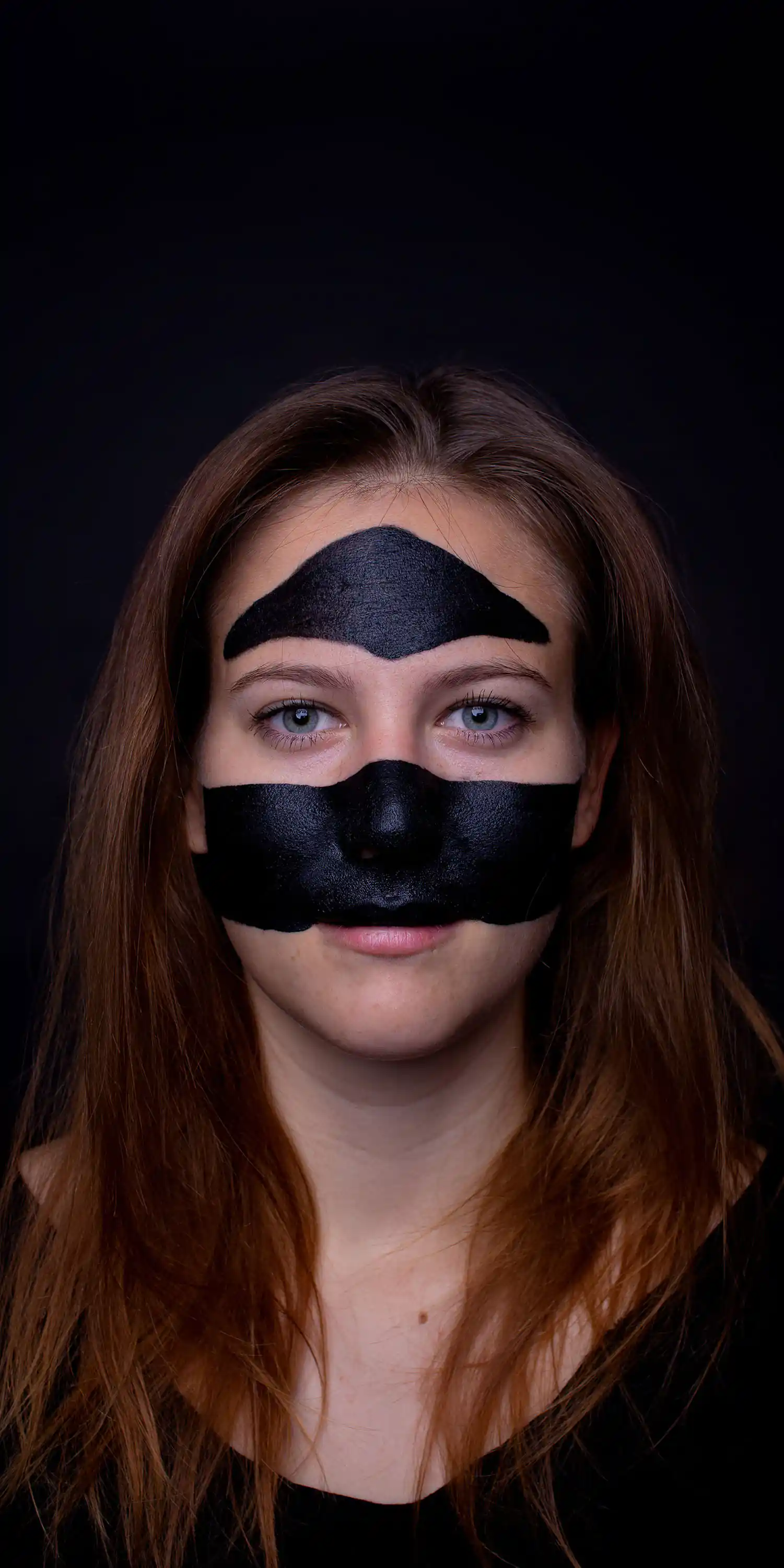 Ein Model mit dreieckiger Gesichtsbemalung, die die Augen ausspart.