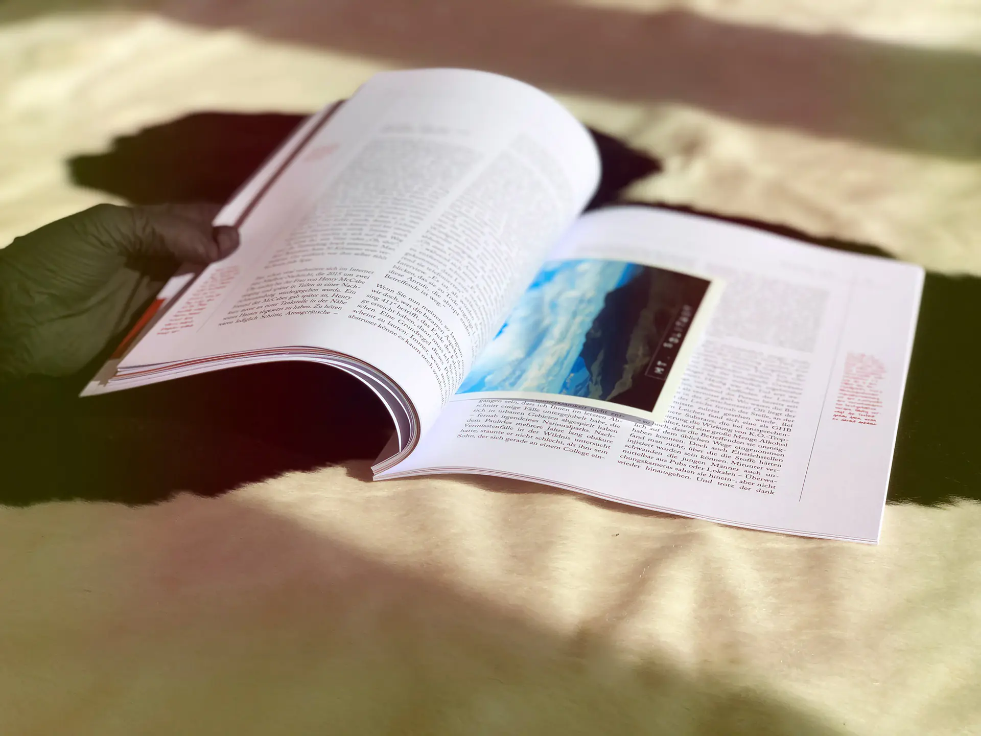 Wenn das Magazin geöffnet ist, sieht man echte Fotos zwischen den Seiten klemmen