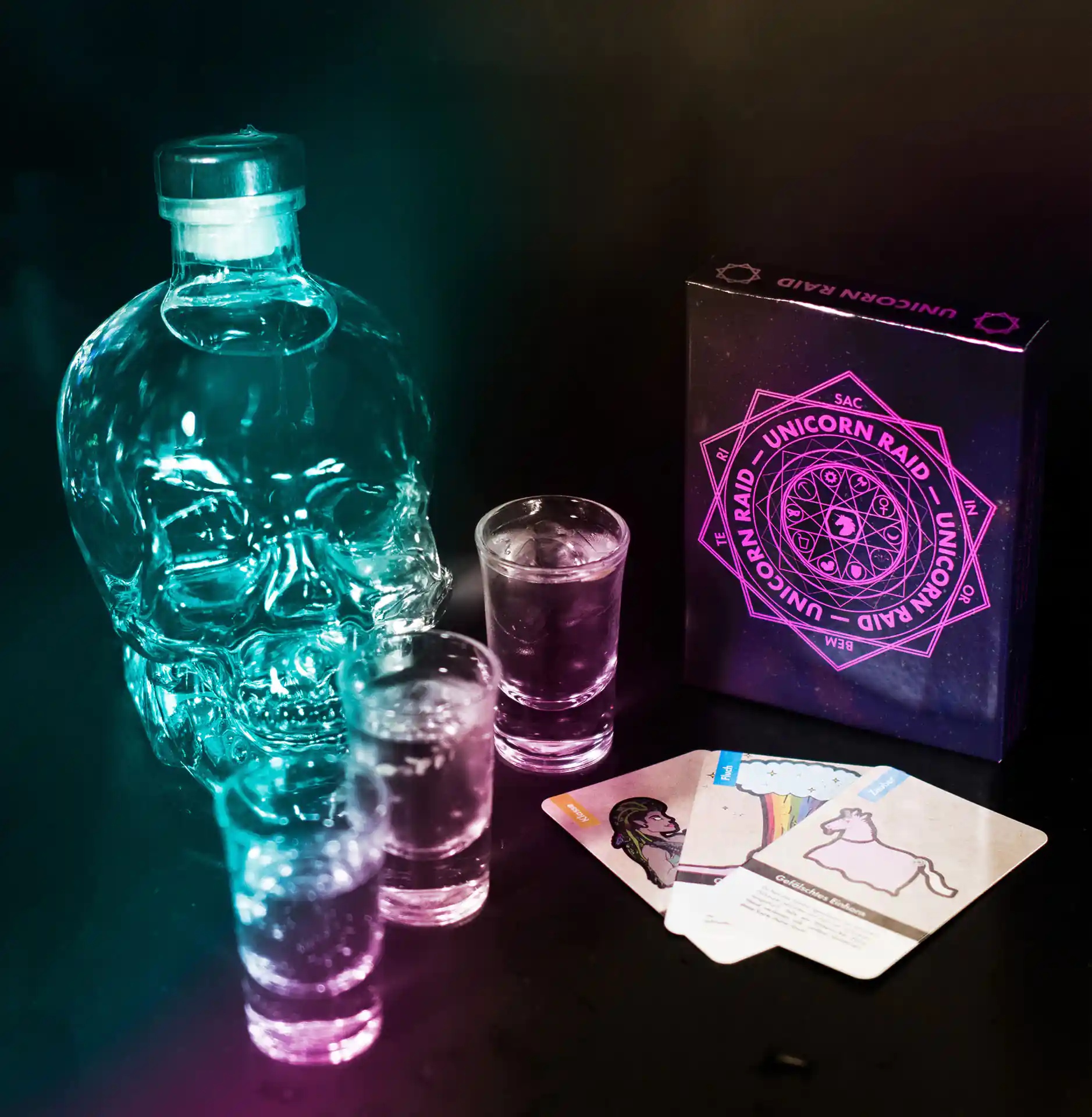 Some glasses as well as a bottle and the card game Unicorn Raid